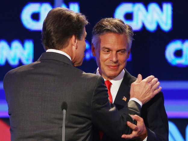 Former Utah Gov. Jon Huntsman (right) and Texas Gov. Rick Perry confer during a break in the Sept. 12 presidential debate in Tampa. Huntsman first objected to Perry's use of the word "treasonous" then later used it himself. 
