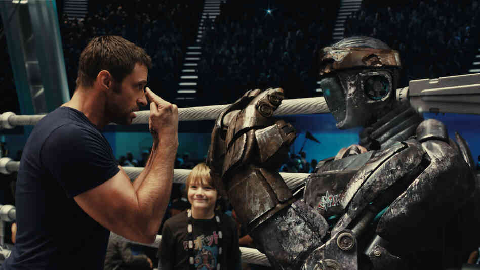 Fists Of Steel: Robot-boxing trainer Charlie Kenton (Hugh Jackman) makes an underdog discovery in Atom, an outdated robot with surprising potential. Fists Of Steel: Robot-boxing trainer Charlie Kenton (Hugh Jackman) makes an underdog discovery in Atom, an outdated robot with surprising potential.