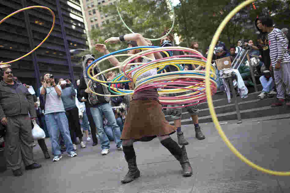 A woman who identified herself as "Marygoround" attempts to balance numerous hula hoops while others toss more at her during the Occupy Wall Street protests in Zuccotti Park, New York, in early October. 