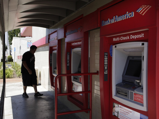 A man walks up to an ATM outside a Bank of America branch in Los Angeles. Bank of America has said it will charge customers a $5 monthly fee to use its debit card — a plan that has set off grumbling from consumer advocates at the highest levels.