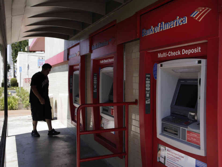 A man walks up to an ATM outside a Bank of America branch in Los Angeles. Bank of America has said it will charge customers a $5 monthly fee to use its debit card — a plan that has set off grumbling from consumer advocates at the highest levels.