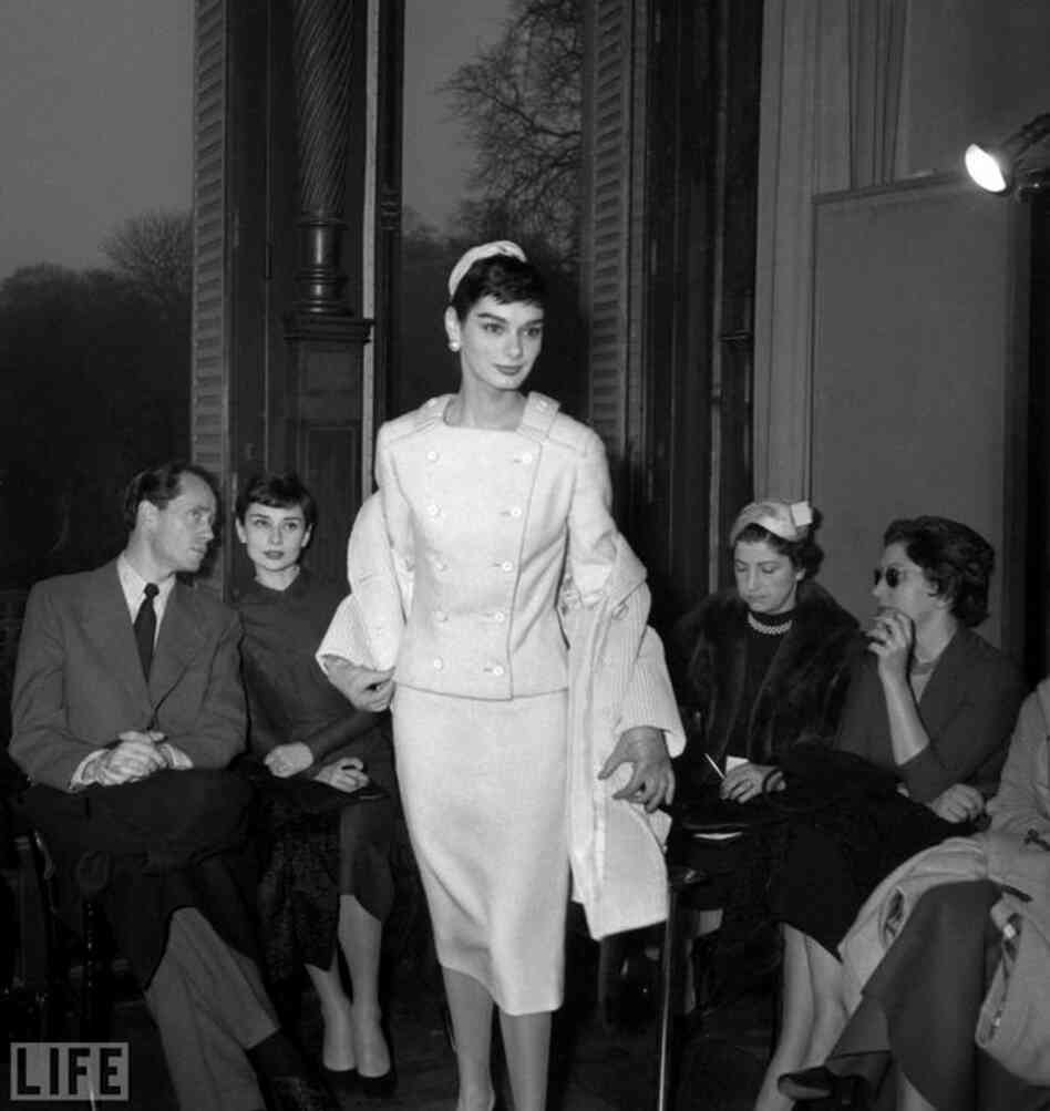 Hepburn (left) sits with her then-husband Mel Ferrer at a 1955 Givenchy show in Paris. 