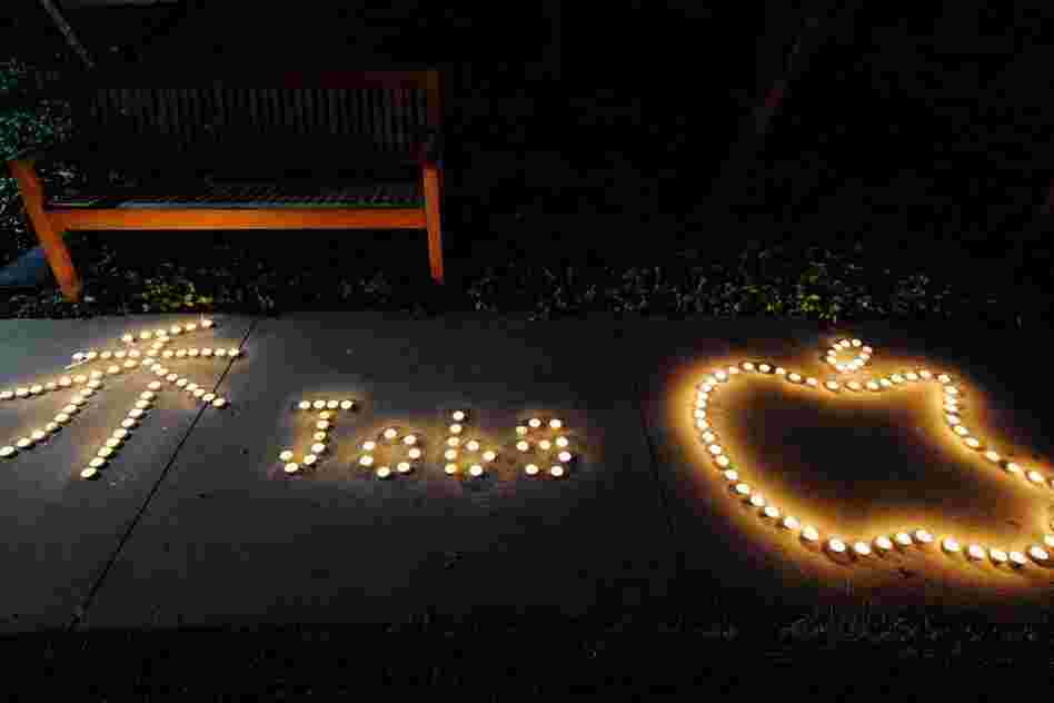 Chinese exchange students from nearby De Anza College use candles to create a makeshift memorial for Steve Jobs at the Apple headquarters. 