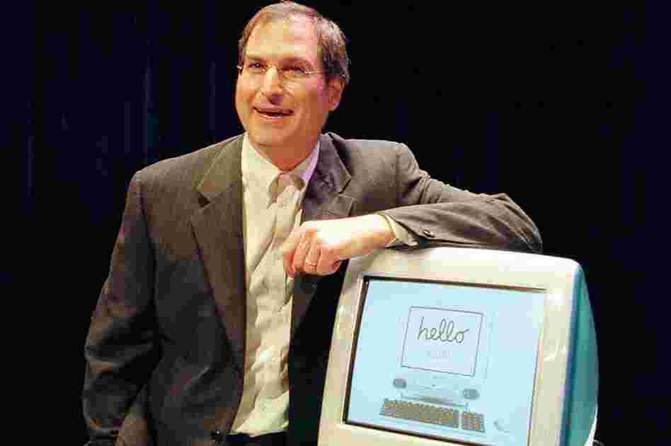Jobs poses with the first iMac in 1998. 
