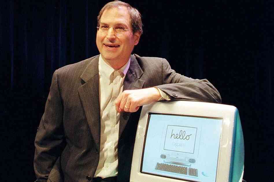 Jobs poses with the first iMac in 1998. 