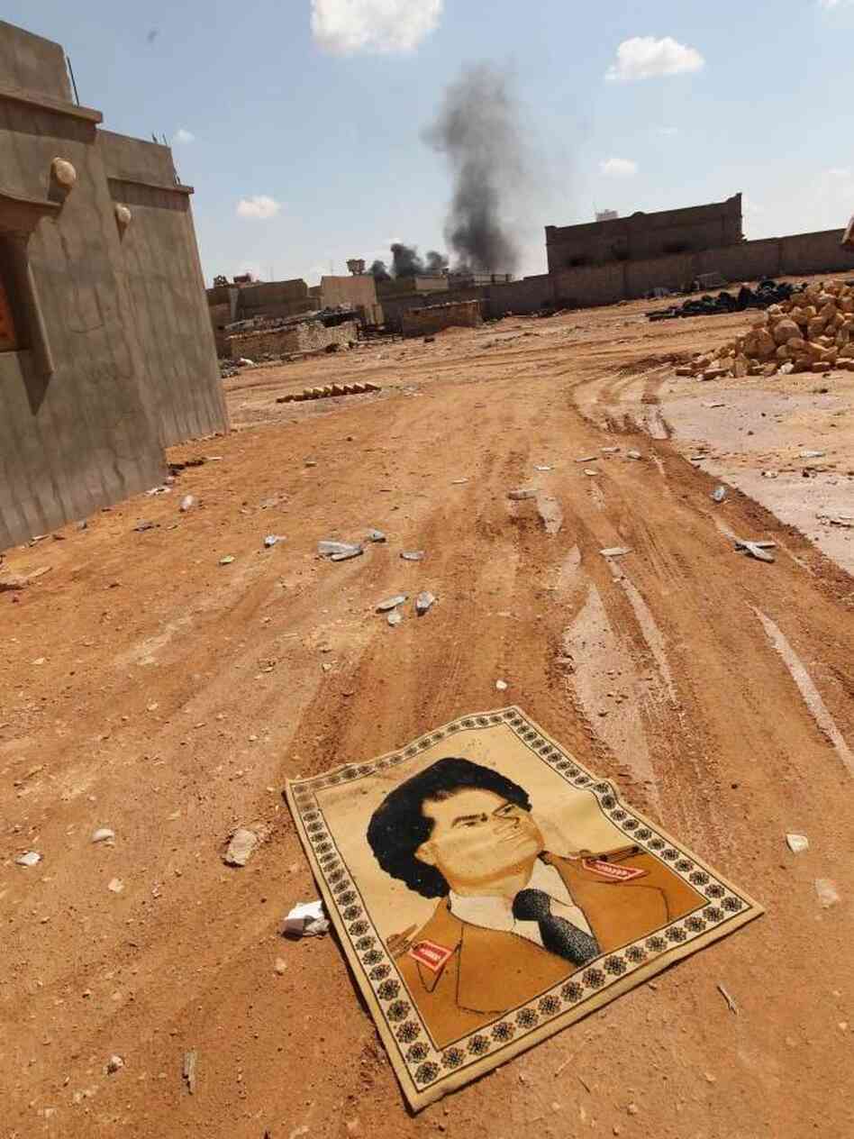 A small carpet with the portrait of Gadhafi lies on the ground near fighting at the front line of Bani Walid, southeast of Tripoli, earlier this month. A small carpet with the portrait of Gadhafi lies on the ground near fighting at the front line of Bani Walid, southeast of Tripoli, earlier this month.