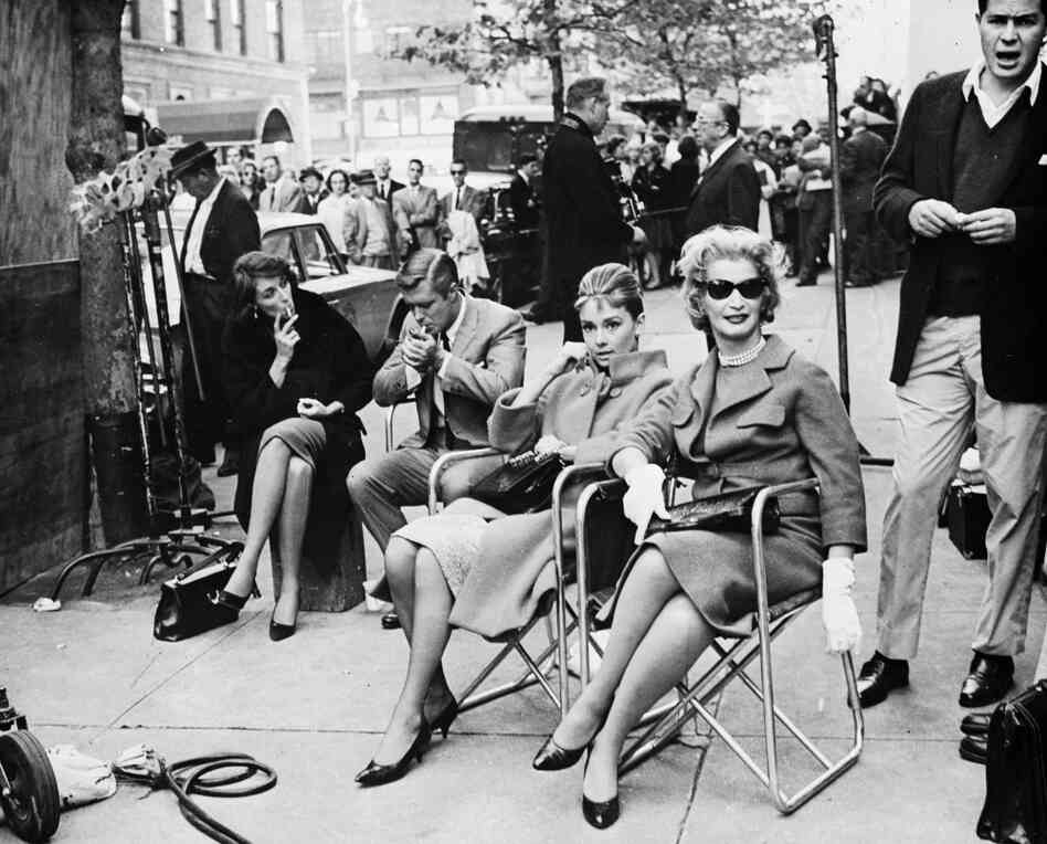 Actors, including Audrey Hepburn, take a break during location filming for Breakfast At Tiffany's in 1961.