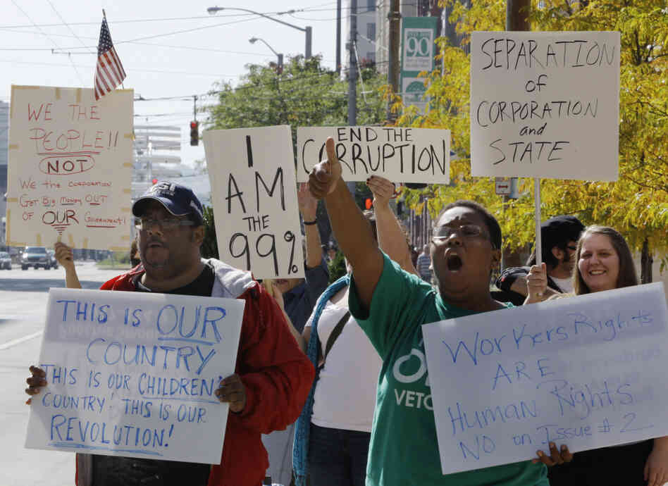 Protesters organized by Occupy Wall Street and Occupy Together yell slogans and hold signs at Courthouse Square in Dayton, Ohio, Wednesday. Several large unions have come out in support of Occupy Wall Street.