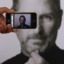 A photographer uses his iPhone to take a picture of a tribute to Apple co-founder Steve Jobs in front of an Apple store in London. Jobs, 56, died Wednesday after a long battle with pancreatic cancer. A photographer uses his iPhone to take a picture of a tribute to Apple co-founder Steve Jobs in front of an Apple store in London. Jobs, 56, died Wednesday after a long battle with pancreatic cancer.