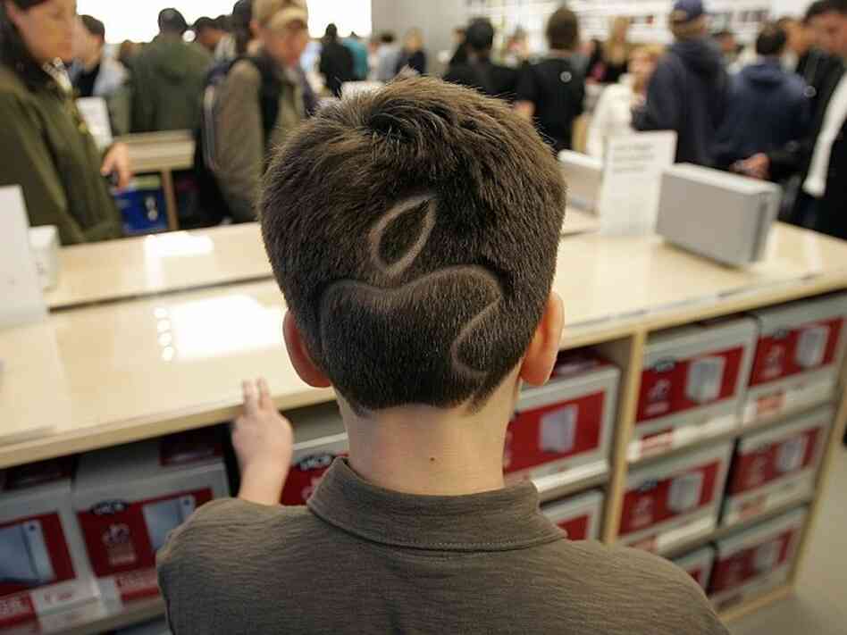 Allen Paltrow-Krulwich sports the apple logo in his hair at the grand opening of the new Apple Store on 5th Avenue in New York May 19, 2006.