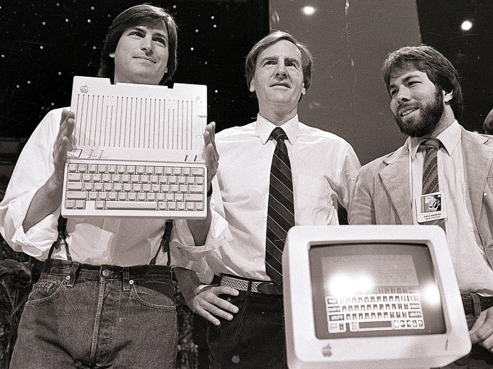 April 24, 1984, from left to right: Steve Jobs, John Sculley and Steve Wozniak unveil the new Apple IIc computer in San Francisco.