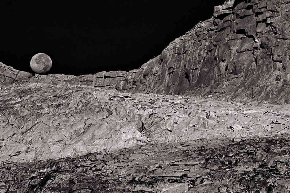 A setting moon makes a fitting backdrop for a lunarlike landscape near Donohue Pass.