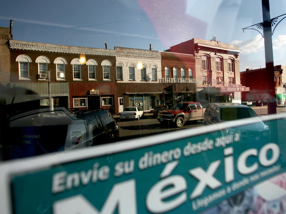 Sending money to relatives in Mexico is a popular way for families to support each other. West Liberty's East 3rd Street is reflected in this window. 