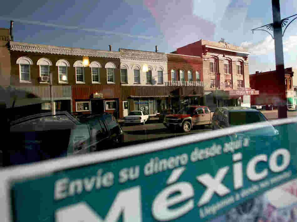 Sending money to relatives in Mexico is a popular way for families to support each other. West Liberty's East 3rd Street is reflected in this window. 