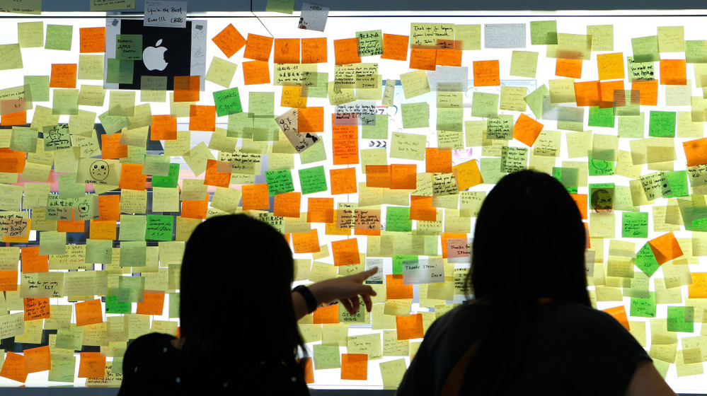 Messages posted on a glass window pay tribute to the late Apple co-founder Steve Jobs outside the Apple store in Hong Kong.