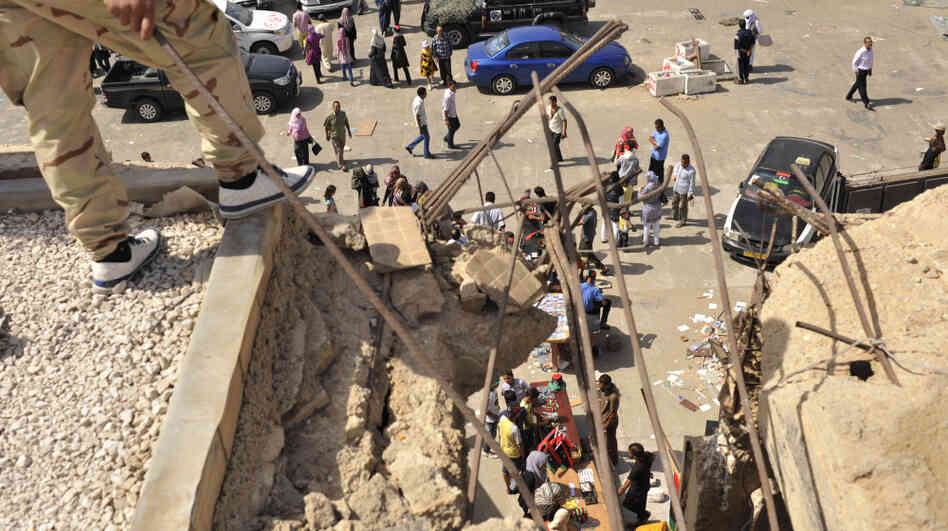 Libyans visit the destroyed Bab al-Azizia military barracks and compound of their country's ousted leader Moammar Gadhafi, in the southern suburbs of Tripoli, Libya.