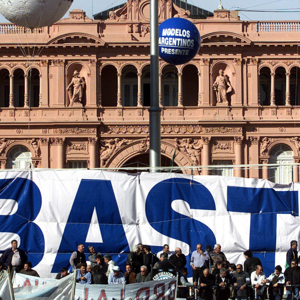 Labor union leaders take part in a protest with a giant banner reading "Basta" ("Enough") before the presidential palace in Buenos Aires in 2001. At the time, the country was mired in a three-year recession and facing default on its $128 billion public debt.