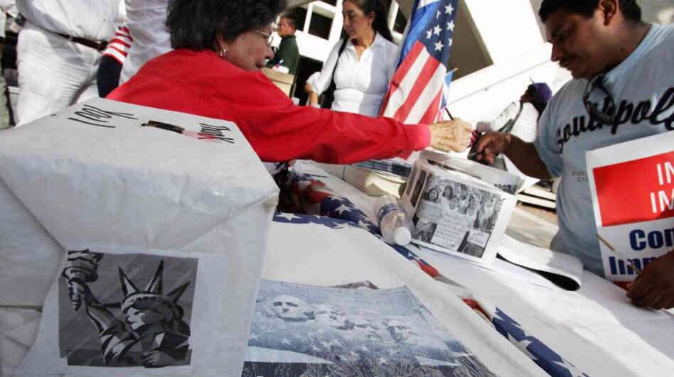 An immigrant signs a voter registration information card at a booth set up at a rally in downtown Miami in 2007. If a new law is upheld, the time period groups have to turn in new voter registrations will be reduced from 10 days to two.