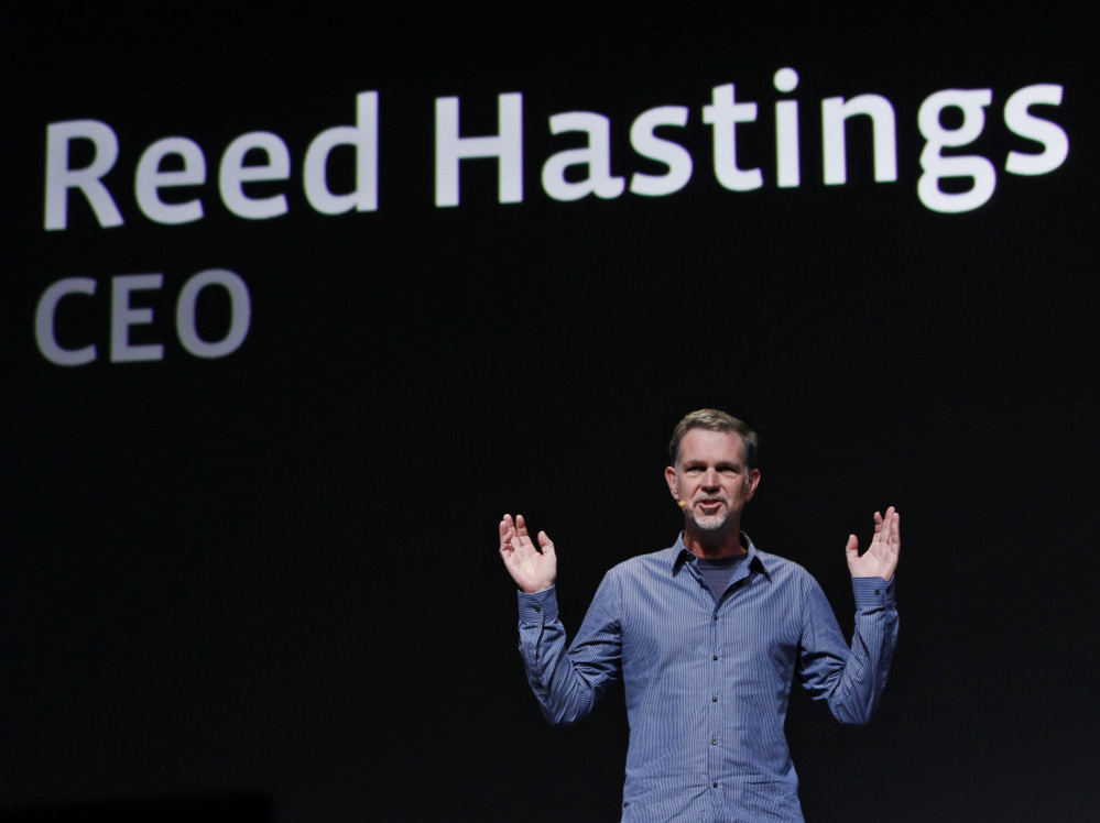 Netflix has backed off its unpopular plan to split its service into two offerings — one for streaming video, and one for sending DVDs by mail. CEO Reed Hastings is seen gesturing in this file photo.