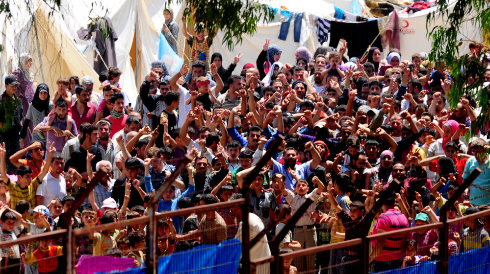 Syrian refugees gather to protest Syrian President Bashar Assad at the Turkish Red Crescent camp in the Yayladagi district of the Turkish city of Hatay near the Syrian border on June 20. More than 7,000 Syrians are living in camps in Turkey.