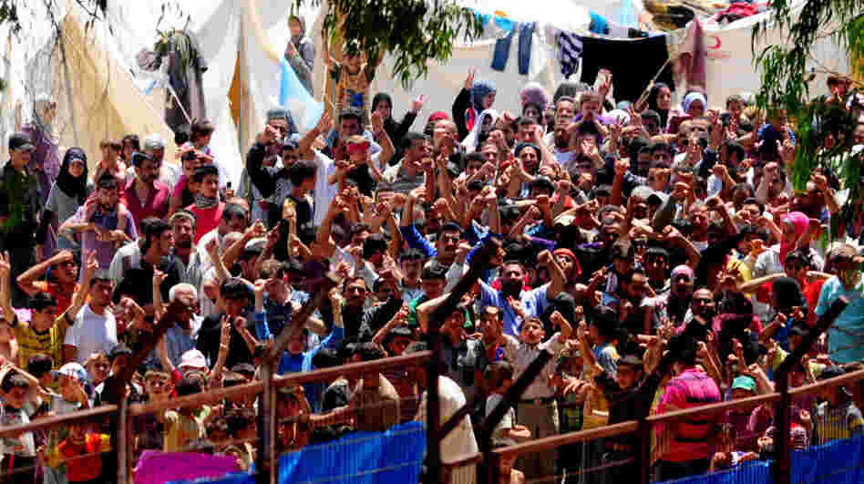 Syrian refugees gather to protest Syrian President Bashar Assad at the Turkish Red Crescent camp in the Yayladagi district of the Turkish city of Hatay near the Syrian border on June 20. More than 7,000 Syrians are living in camps in Turkey.