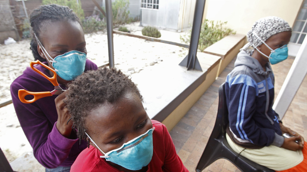 A woman, left, cuts the hair of a fellow tuberculosis patient at a clinic in the township of Khayelitsha, on the outskirts of Cape Town, South Africa, in March.
