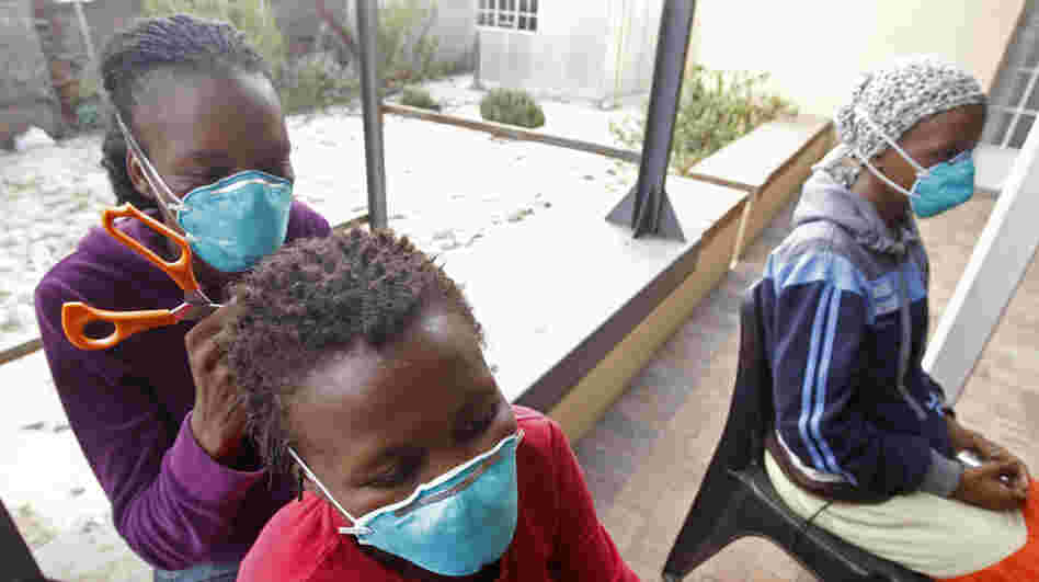 A woman, left, cuts the hair of a fellow tuberculosis patient at a clinic in the township of Khayelitsha, on the outskirts of Cape Town, South Africa, in March.