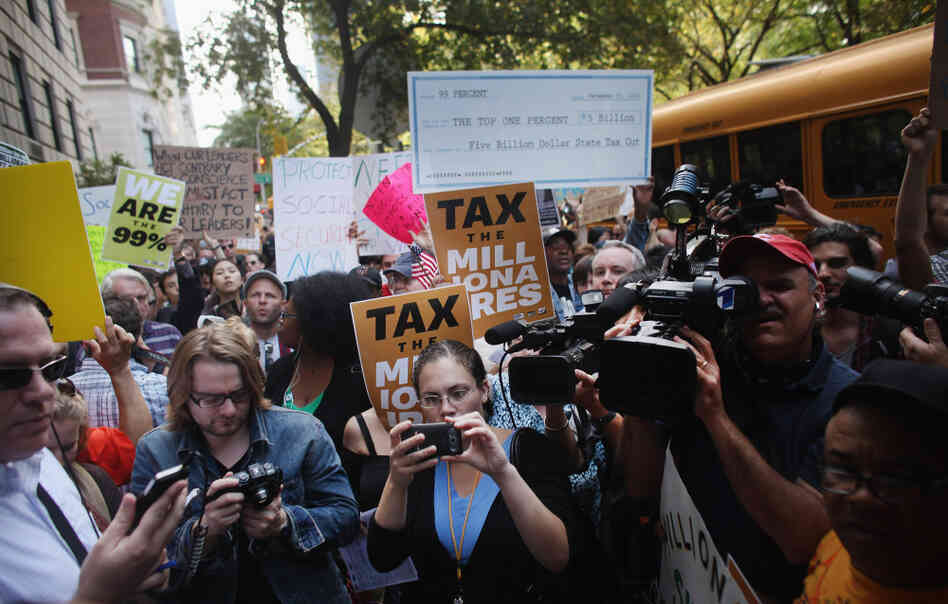 Protesters with Occupy Wall Street march along New York's 5th Avenue, where prominent heads of major business and financial institutions live, on Tuesday. The movement has expanded, along with media coverage.
