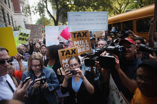 Protesters with Occupy Wall Street march along New York's 5th Avenue, where prominent heads of major business and financial institutions live, on Tuesday. The movement has expanded, along with media coverage.