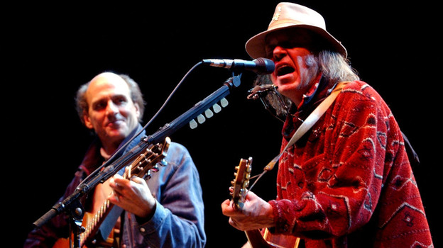 Neil Young performs with James Taylor at the 16th annual Bridge School benefit concert on Oct. 26, 2002.