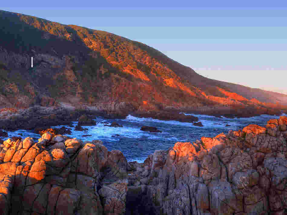 Researchers found paint and tools in the Blombos cave, marked with the white arrow on the left side of the image, on the southern coast of South Africa.