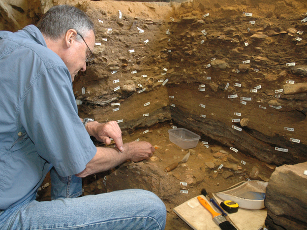 Archaeologist Christopher Henshilwood excavates at the 100,000-year-old levels of the Blombos cave in South Africa.