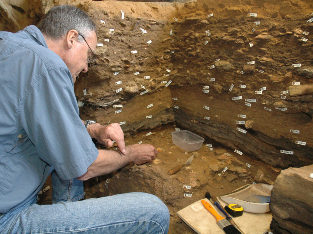 Archaeologist Christopher Henshilwood excavates at the 100,000-year-old levels of the Blombos cave in South Africa.