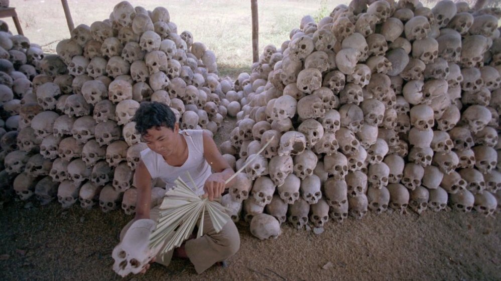 In this undated photo, a man cleans a skull near a mass grave at the Choeung Ek camp outside Phnom Penh, Cambodia — the best known of the killing fields run by the Khmer Rouge in the middle and late 1970s. Now, Cambodians are skeptical that a U.N.-backed tribunal will be able to deliver justice in the case of four remaining high-level Khmer Rouge officials.