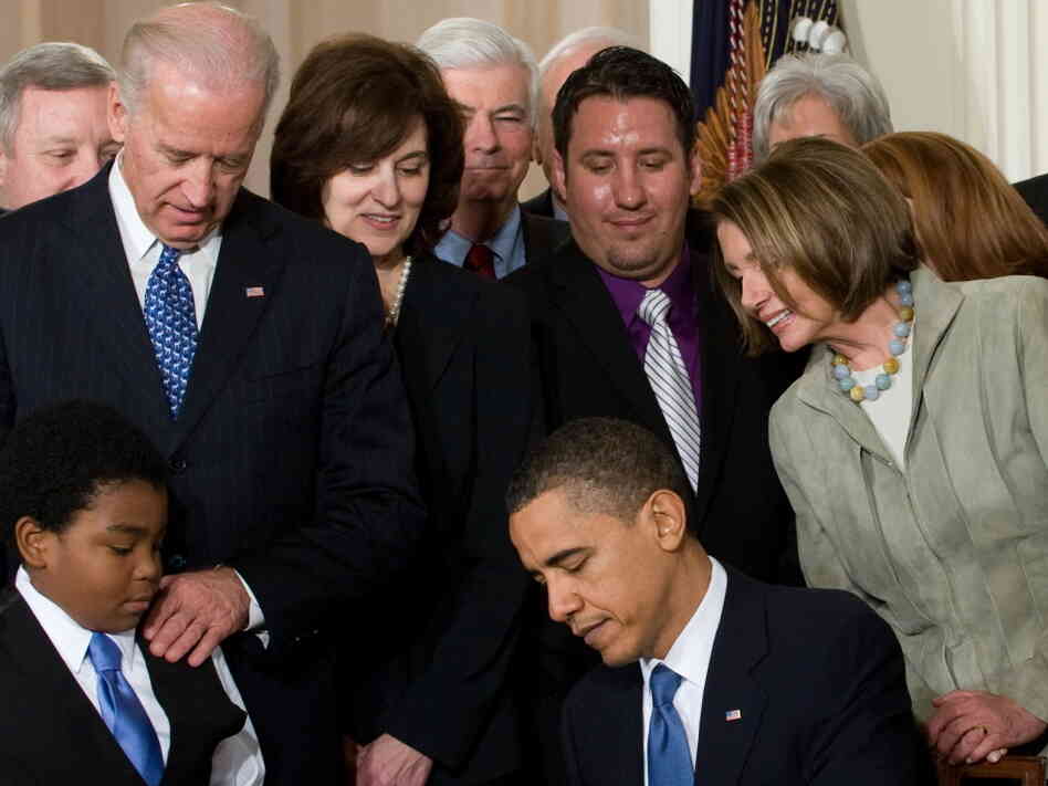 President Obama, surrounded by lawmakers and guests, signs health care insurance legislation during a ceremony in the East Room of the White House on March 23, 2010. President Obama, surrounded by lawmakers and guests, signs health care insurance legislation during a ceremony in the East Room of the White House on March 23, 2010.