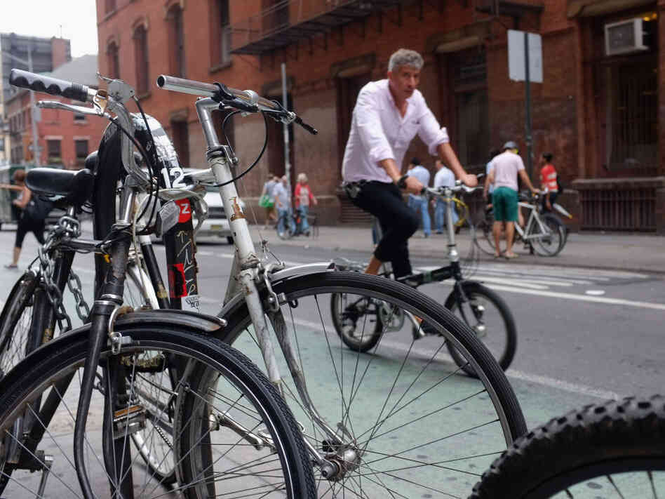 A man rides down a Manhattan street on a bicycle in New York City. A man rides down a Manhattan street on a bicycle in New York City.