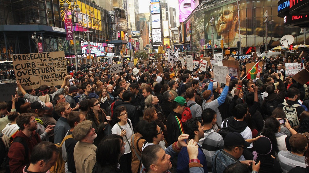Demonstrators protest in New York's Time Square on Saturday. Thousands of people took to the streets in cities across the world, inspired by the Occupy Wall Street protests against economic inequality.