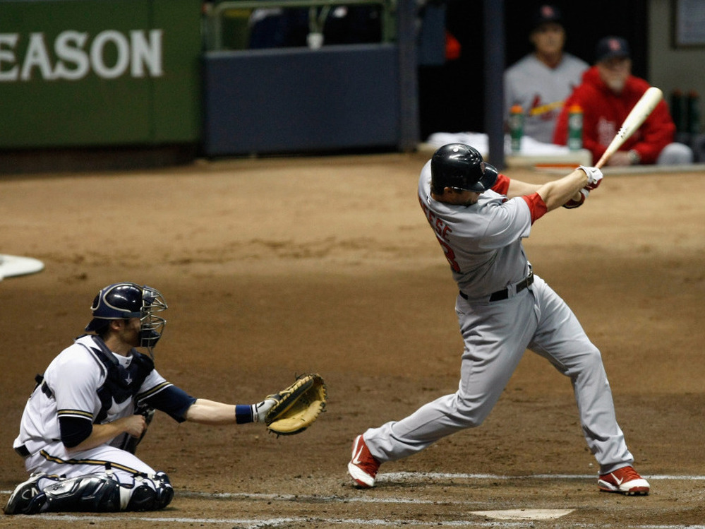 David Freese of the St. Louis Cardinals hits a 3-run home run in the top of the first inning against the Milwaukee Brewers.