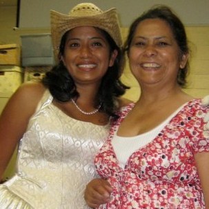 Malin Alegria often wears quinceanera dresses to her book readings. She says that when she was young, she had a hard time accepting the cultural pride her mother (right) tried to instill in her.