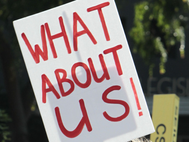 In California, where deep deficits have roiled the education system, a young protester holds a sign against layoffs and other cuts during a demonstration this past May.