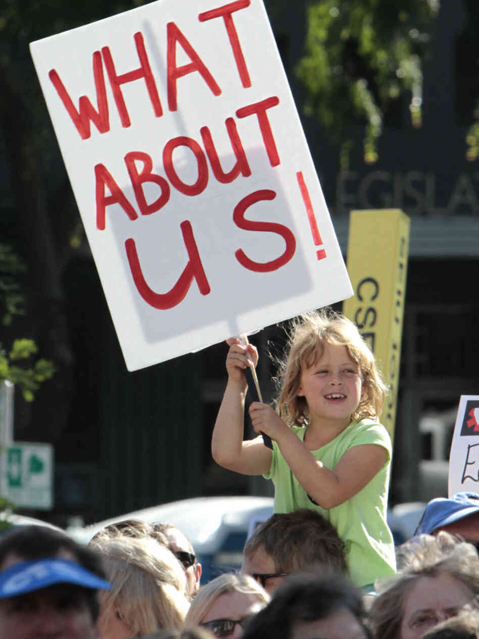 In California, where deep deficits have roiled the education system, a young protester holds a sign against layoffs and other cuts during a demonstration this past May.