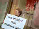 During an Occupy Chicago demonstration at the Bank of America building in Chicago, Kaye Gamble holds a sign protesting corporate greed. During an Occupy Chicago demonstration at the Bank of America building in Chicago, Kaye Gamble holds a sign protesting corporate greed.