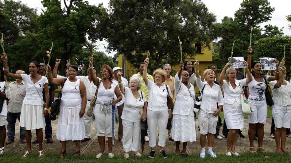 Members of dissident group Ladies in White yell "Laura lives!" during their weekly march in front of Santa Rita church in Havana on Sunday. Cuba's Ladies in White have vowed to keep protesting against the island's Communist-run government despite the death of their late founder, Laura Pollan, but the loss presents new challenges for a dissident group already struggling to be visible.