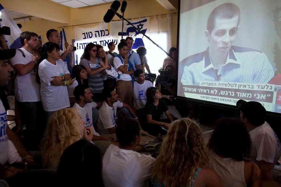 People in Mitzpe Hila watch the first televised images of the 25-year-old Shalit, who doctors said shows signs of malnutrition, following his release. 