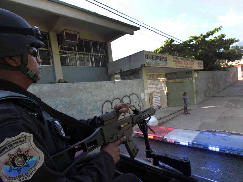 A federal policeman in Mexico patrols the outskirts of Acapulco, Guerrero state, earlier this month. Acapulco has seen a sharp drop in tourism as criminals battle for control of the city. 