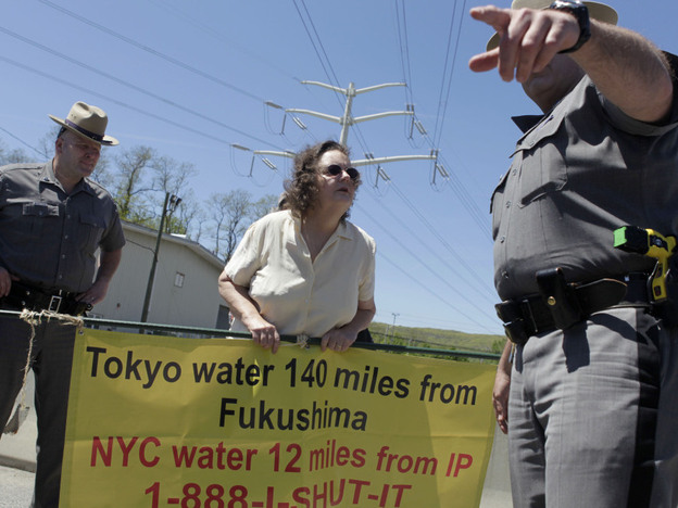 Marilyn Elie (center) of Cortlandt Manor, N.Y., is escorted off the grounds of the Indian Point Energy Center during a protest in May. Elie was there with a half-dozen others to voice opposition to the re-licensing of the nuclear facility. 