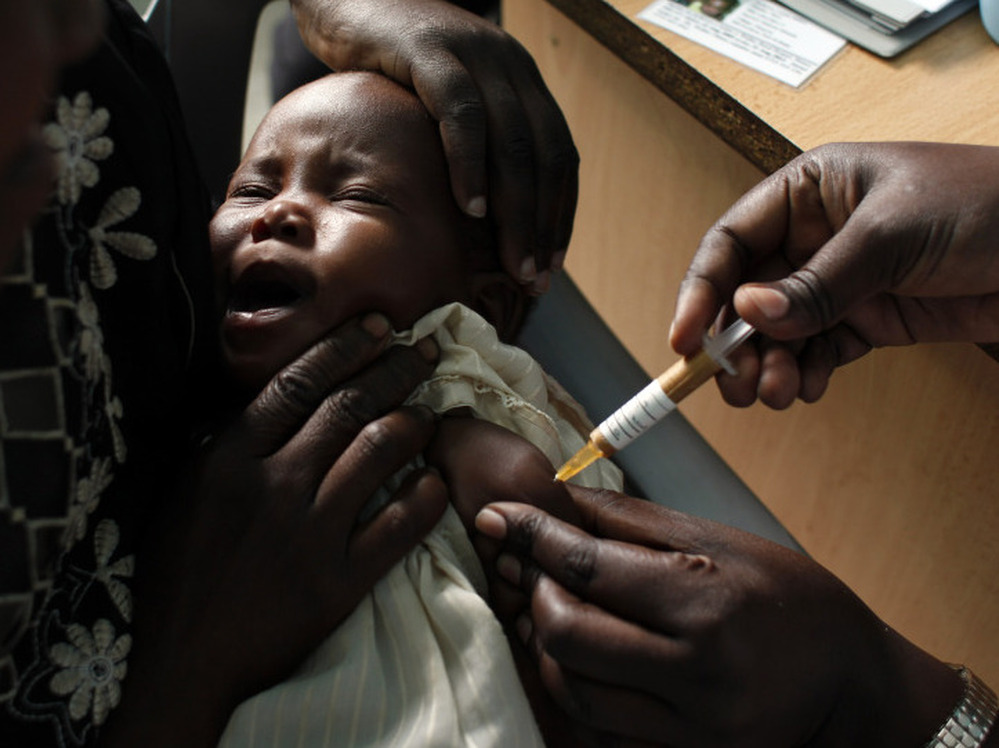 A mother held her baby as she received an experimental malaria vaccine at the Walter Reed Project Research Center in Kombewa in Western Kenya in Oct. 2009. 