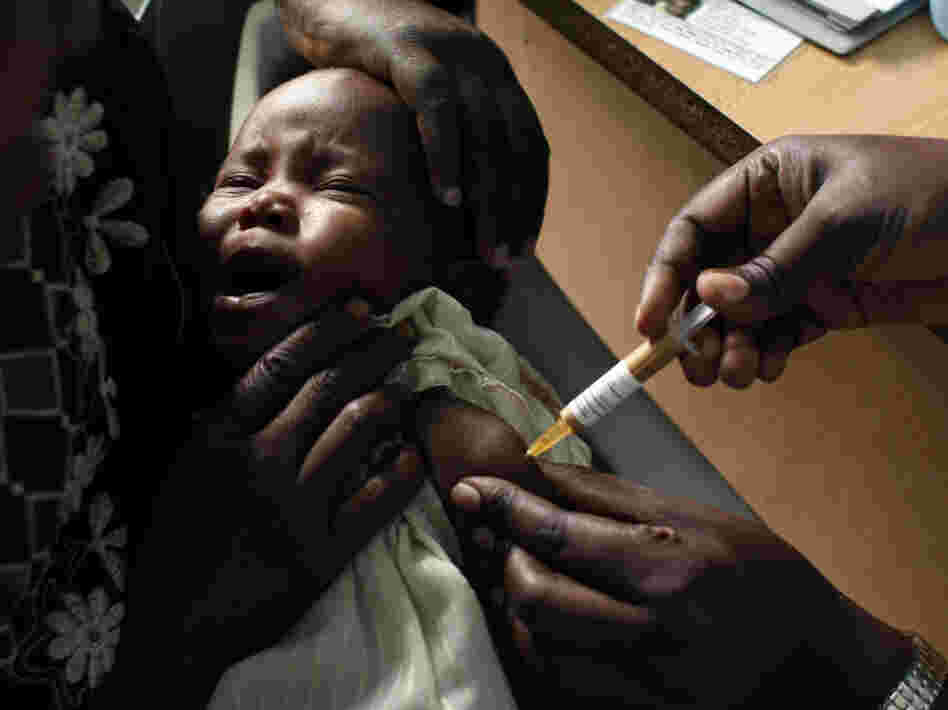 A mother held her baby as she received an experimental malaria vaccine at the Walter Reed Project Research Center in Kombewa in Western Kenya in Oct. 2009. 