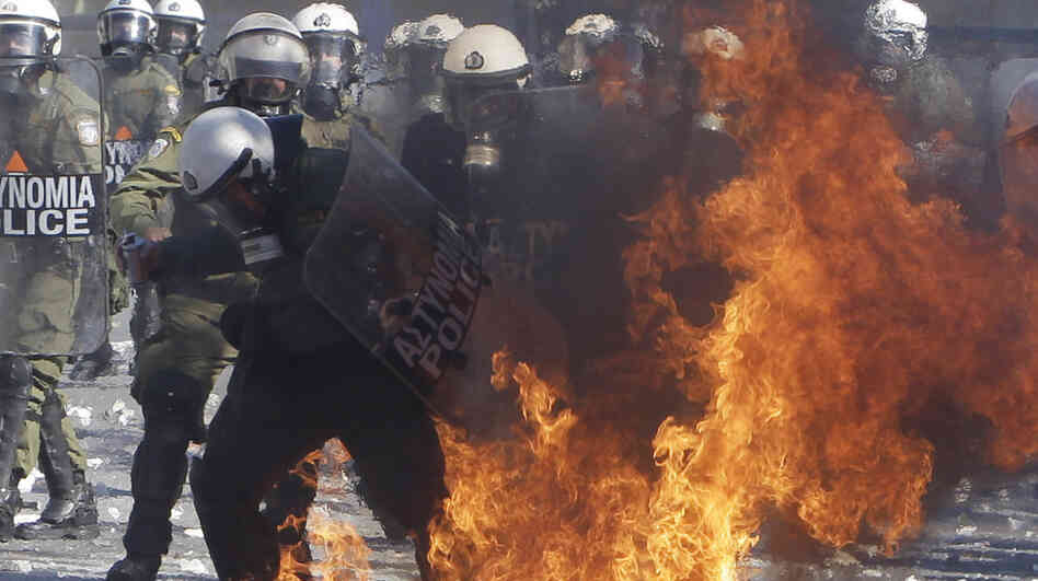 A riot policeman's clothing catches fire after being hit by a gasoline bomb during clashes with protesters Wednesday outside the Greek Parliament in Athens. A riot policeman's clothing catches fire after being hit by a gasoline bomb during clashes with protesters Wednesday outside the Greek Parliament in Athens.