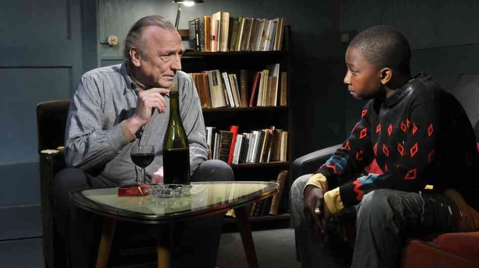 French Resistance: Aging bohemian Marcel (André Wilms) schemes to keep Idrissa (Blondin Miguel), a young Gabonese refugee in Le Havre, from getting deported. French Resistance: Aging bohemian Marcel (André Wilms) schemes to keep Idrissa (Blondin Miguel), a young Gabonese refugee in Le Havre, from getting deported.